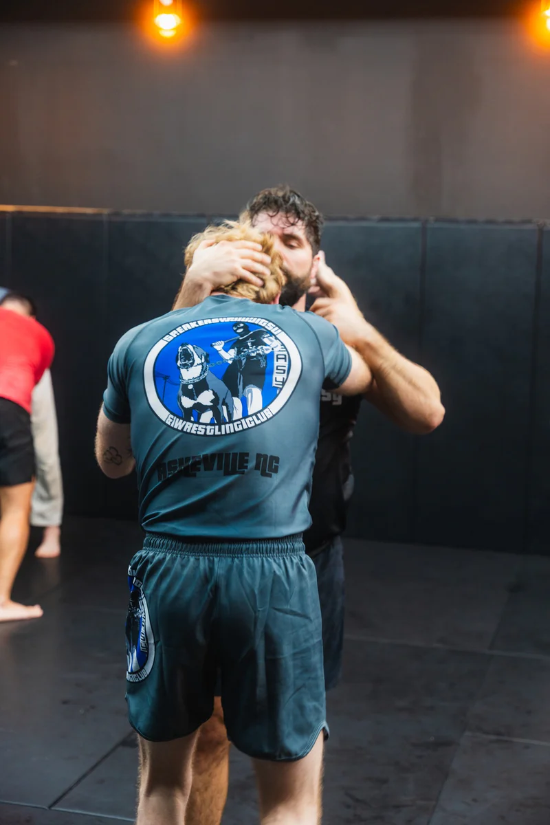 Adults practicing Brazilian Jiu-Jitsu with coaching