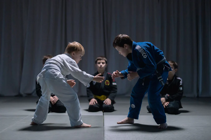 Two children practicing Brazilian Jiu-Jitsu in gis